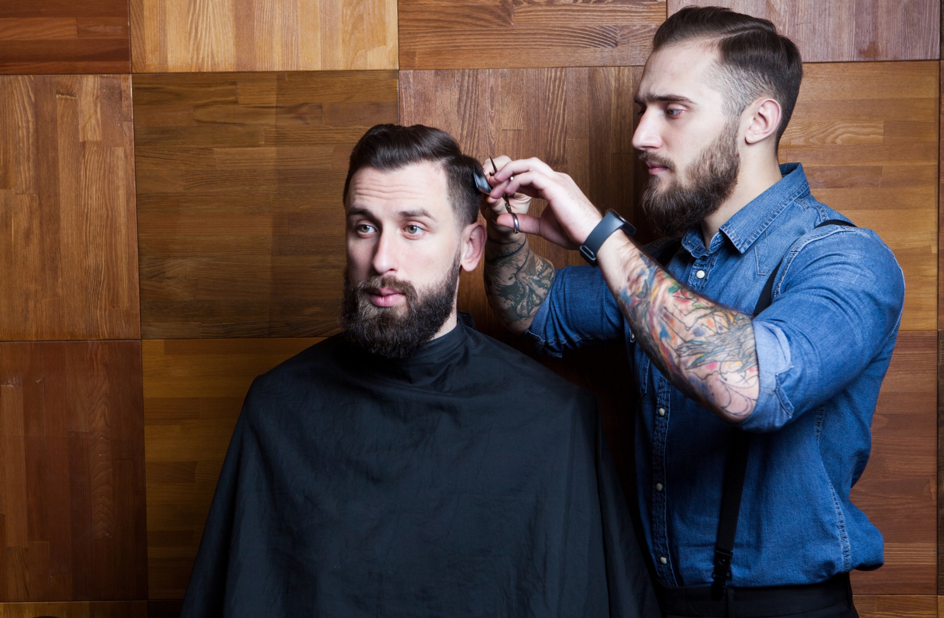 美容師に髪を切られる男性